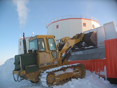 [FillingMelter.jpg]
Jean filling the snow melter, something that needs to be done several times a day in summer, otherwise the level drop down too much or the water heats up too much. The heating is provided directly by the power generator through pipes running at the bottom of the melter: we try to recycle heat as much as possible.