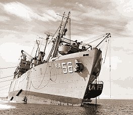 [AKA56.jpg]
USS Arneb (AKA-56). The picture was taken a day or two after she was holed. The crew repaired the hole after they tied the ship into the ice shelf, then shifted most of the cargo to create the list to bring the hole above water.