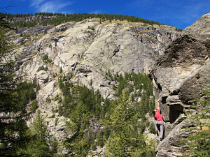 Bouldering granite cracks in Val d'Orco with the main cliff of the Sergent in the background, Gran Paradiso