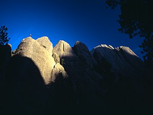 Jenny and Max rappelling in the sunset off a spire, Mt Rushmore